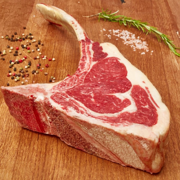 Frisches Bio Tomahawk Steak ganiert mit Salz Pfeffer ud Thymian